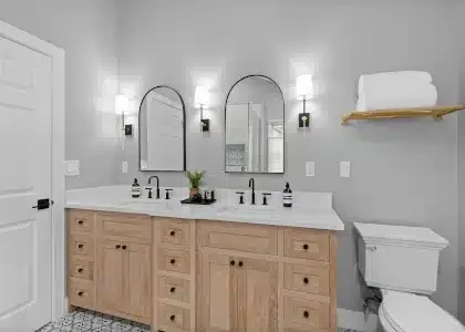 Custom double bathroom vanity in light natural wood with white quartz countertops, dual sinks, and three arched black mirrors in a Palatine remodel.