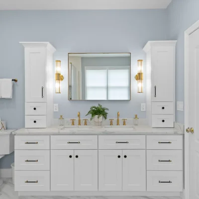 Luxury master bathroom in Palatine featuring a white double vanity with custom countertop storage towers, gold sconce lighting, and brushed brass faucets.