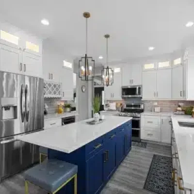 Transitional kitchen remodel in Palatine featuring white shaker cabinets, a navy blue island with quartz countertops, and brushed gold hardware.