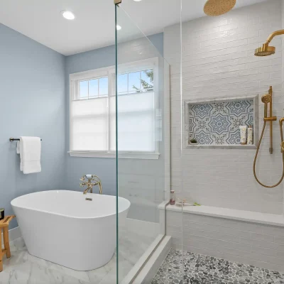 Master bathroom layout in Palatine featuring a freestanding soaking tub adjacent to a glass shower with a built-in quartz bench and pebble flooring.